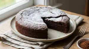 Torta al cioccolato senza burro con zucchero a velo su un piatto di ceramica